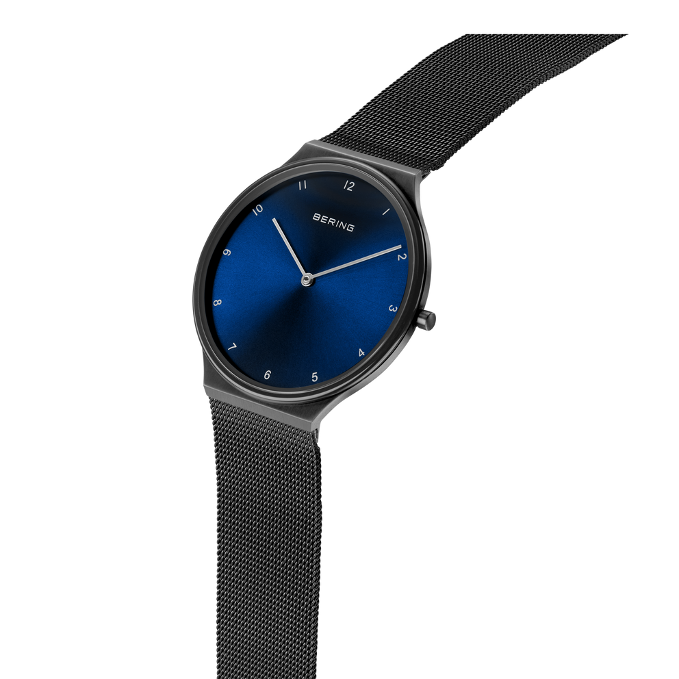 Reloj BERING con esfera azul marino redonda y pulsera de malla negra, vista lateral