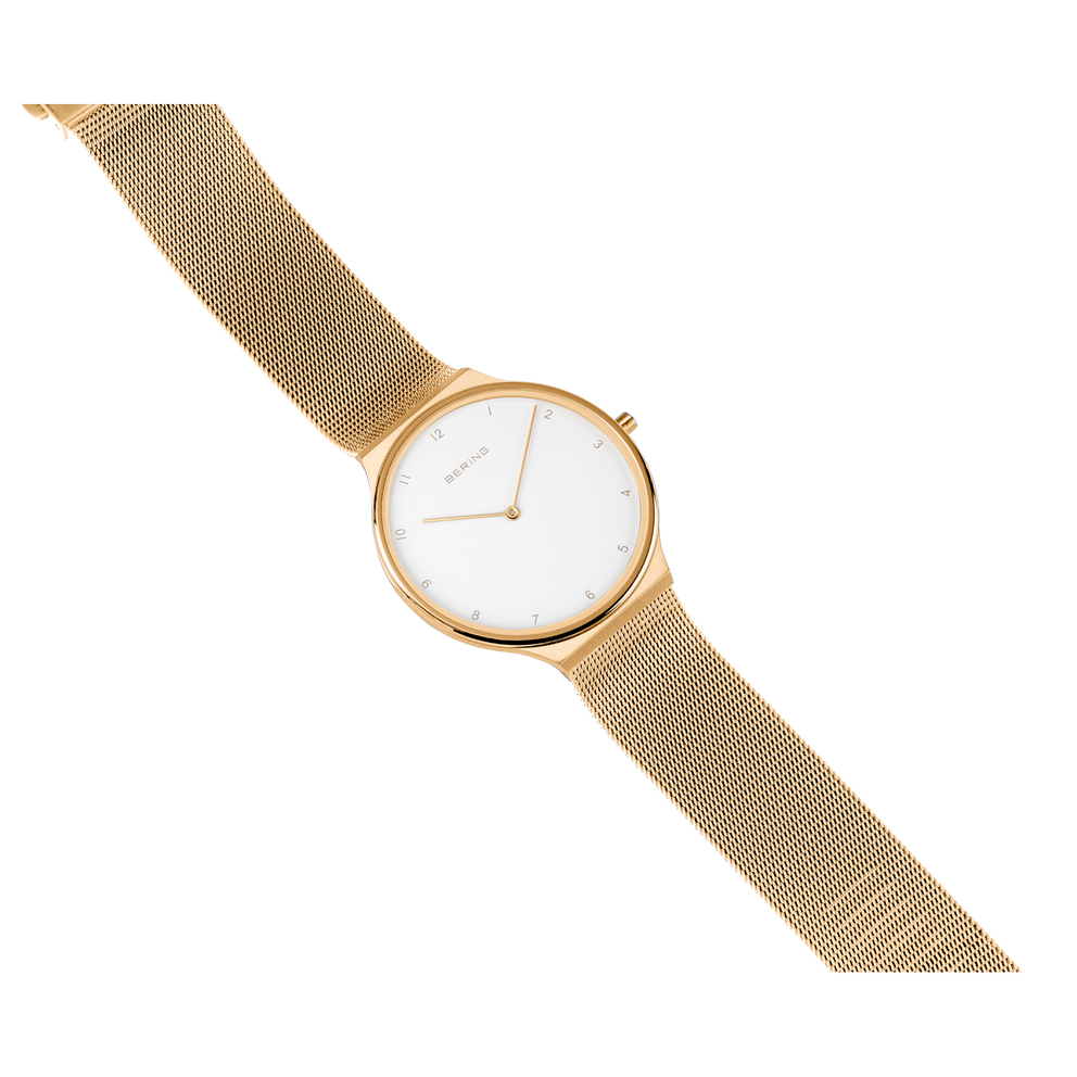 BERING Armbanduhr mit goldenem Gehäuse, cremefarbenem Minimalzifferblatt und Mesh-Armband, Schrägansicht