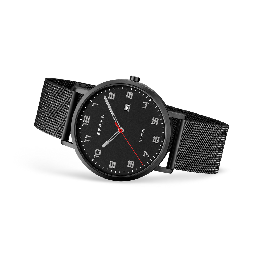 Orologio nero con marcatori di ora bianchi quadrati, cinturino a maglia e lancetta rossa, vista angolata.