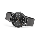 Black wristwatch with mesh band, round dial with white numerals and markers, shown at three-quarter angle.