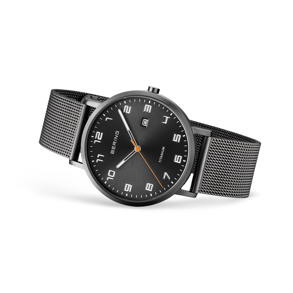 Black wristwatch with mesh band, round dial with white numerals and markers, shown at three-quarter angle.