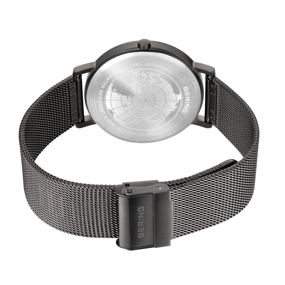 Watch caseback with navigation dial and BERING branding, paired with mesh metal bracelet, photographed from above.