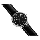 Round wristwatch with black leather strap, silver case, and black dial with Arabic numerals and date window, angled view.