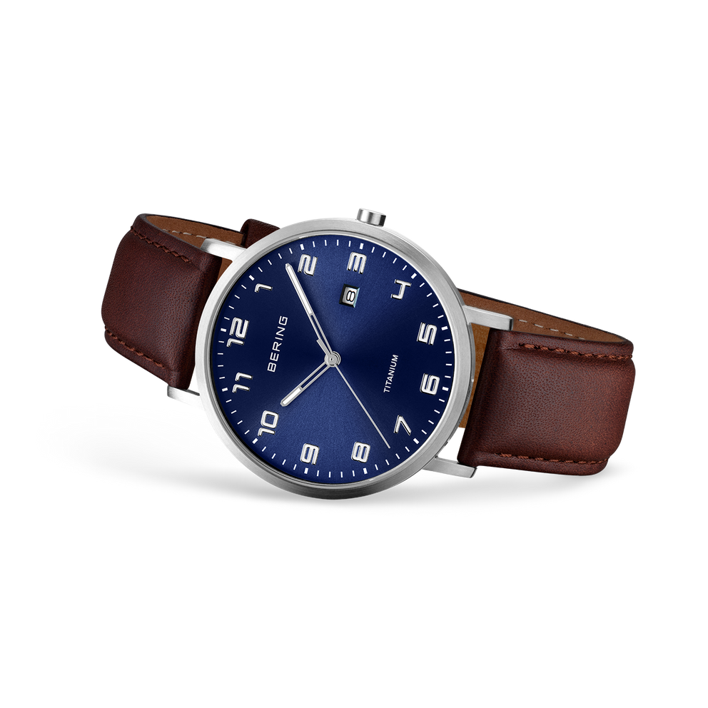 Wristwatch with silver case and dark blue dial, brown leather strap, displayed at three-quarter angle.