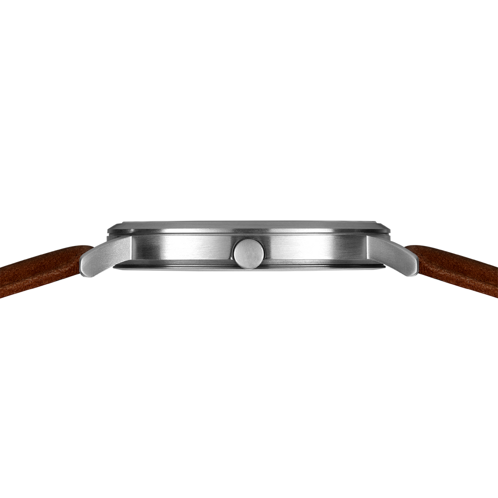 Silver-tone watch case shown in profile with brown leather band, emphasizing slim case design.