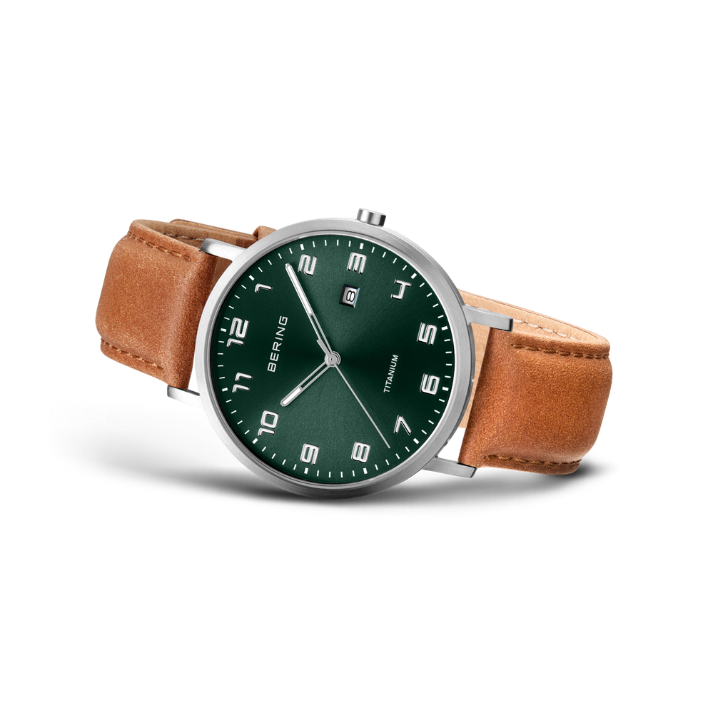 BERING watch with dark green dial, silver case, and brown leather strap, angled view