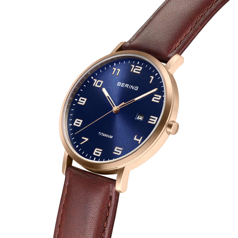 BERING watch with dark blue dial, Arabic numerals, rose gold case, and burgundy leather strap.