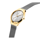 Goldfarbenes Uhr in Schräglage zeigt weißes Zifferblatt und dunkles Netzarmband.