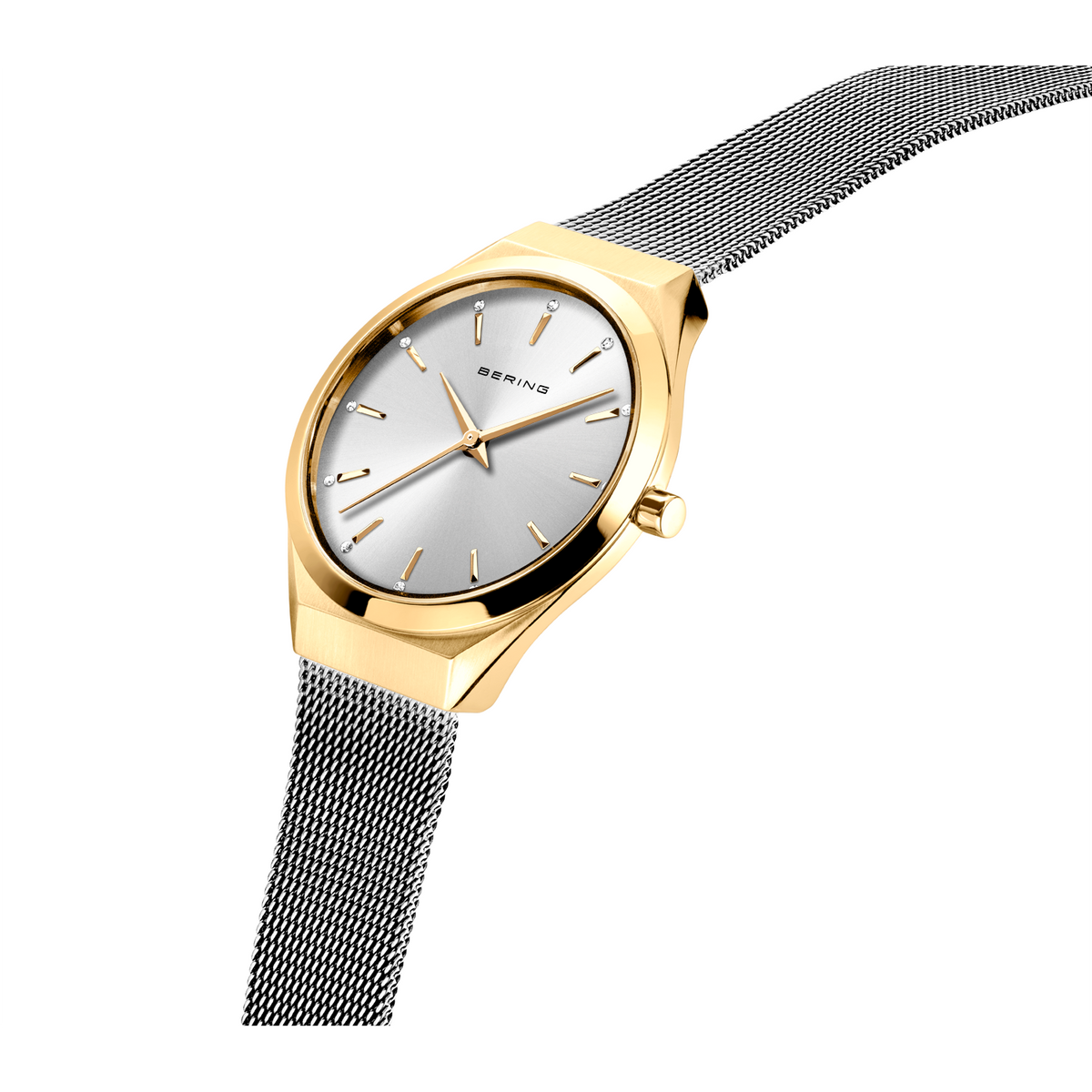 Goldfarbenes Uhr in Schräglage zeigt weißes Zifferblatt und dunkles Netzarmband.