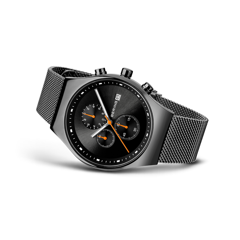 BERING kronografisk armbåndsur med sort skive, tre orange-aksent-underskive og mesh-metalrem.