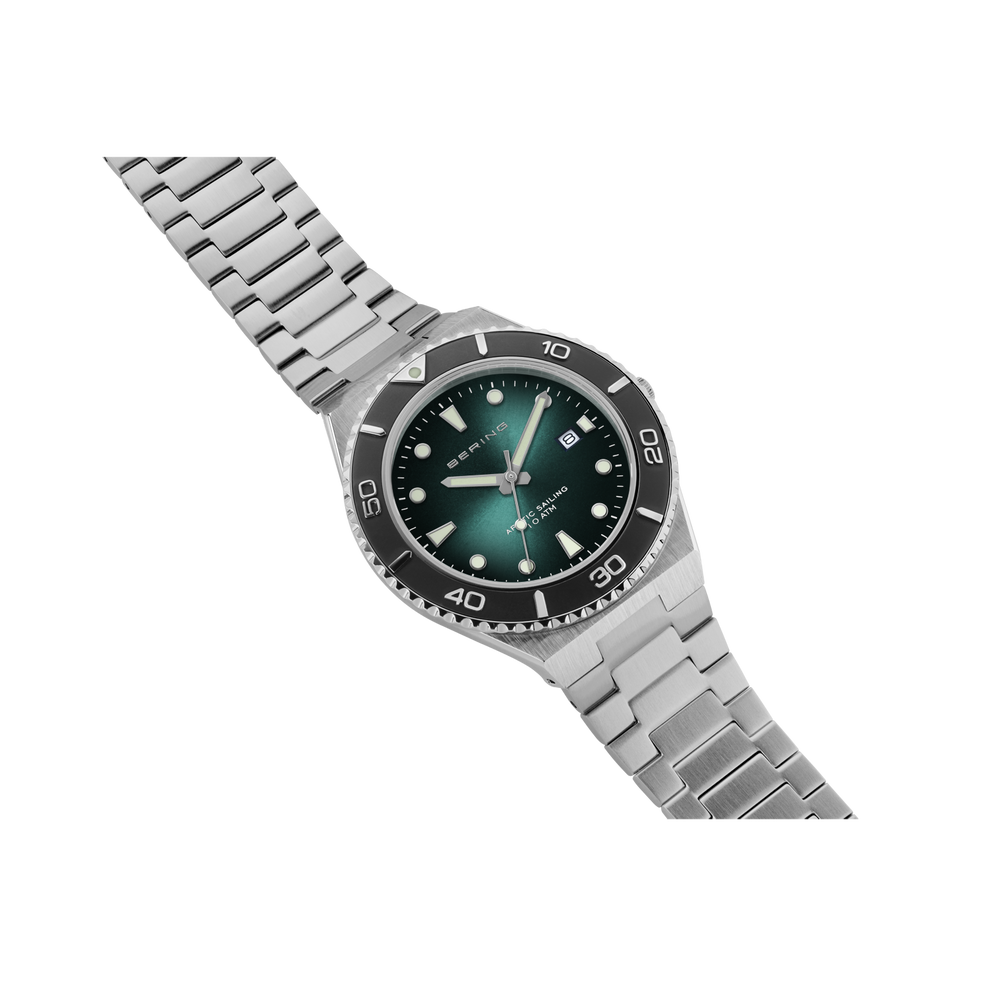 Orologio da polso con quadrante blu scuro, cinturino a maglie d'argento e lunetta nera, ripreso di scorcio.